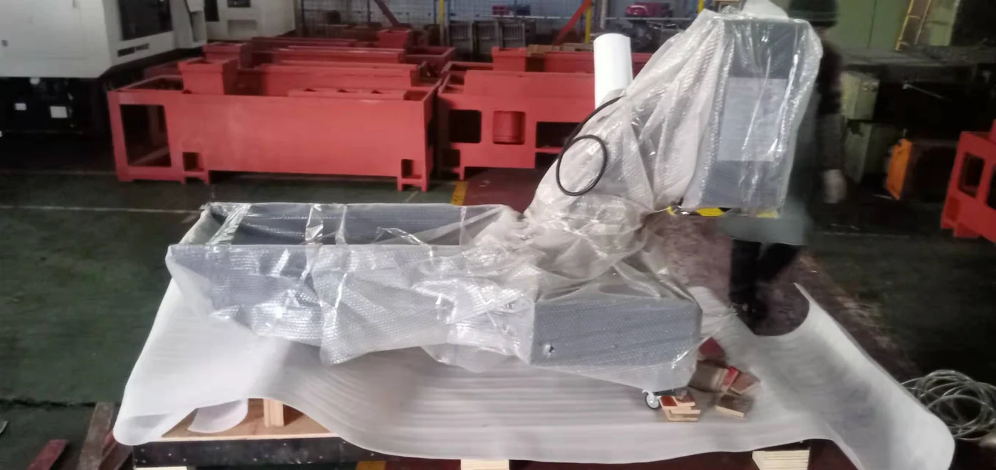 Machine components protected with wrapping and secured on a wooden shipping base.