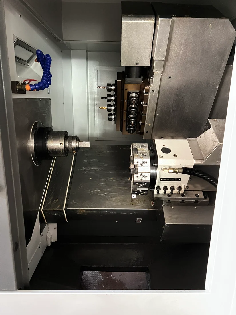 CNC lathe work area with a spindle, toolholders and coolant hoses.