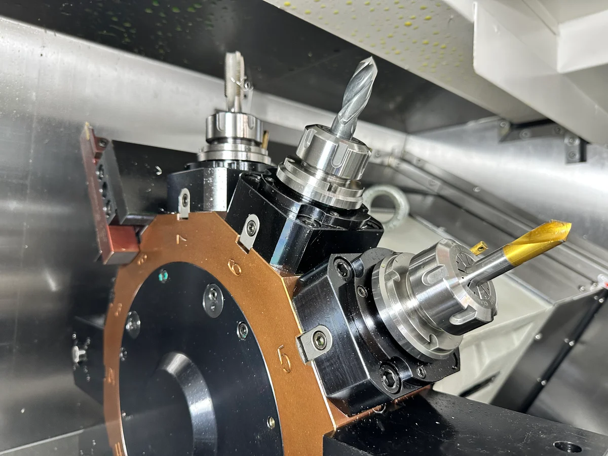 Driven tool holders fitted with a tap and an end mill on a lathe turret